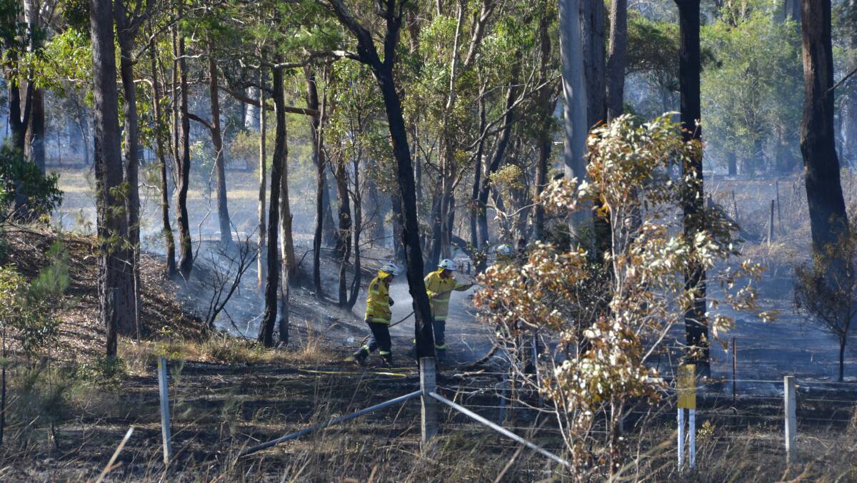 RFS crews mop up a grass fire at Kundabung. (Picture by Emily Walker)