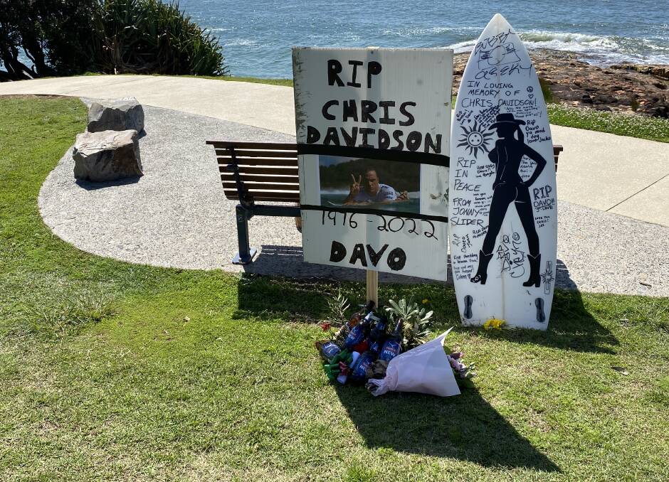 Flowers and beer bottles sit at the bottom of a memorial to Chris Davidson. Picture by Ellie Chamberlain