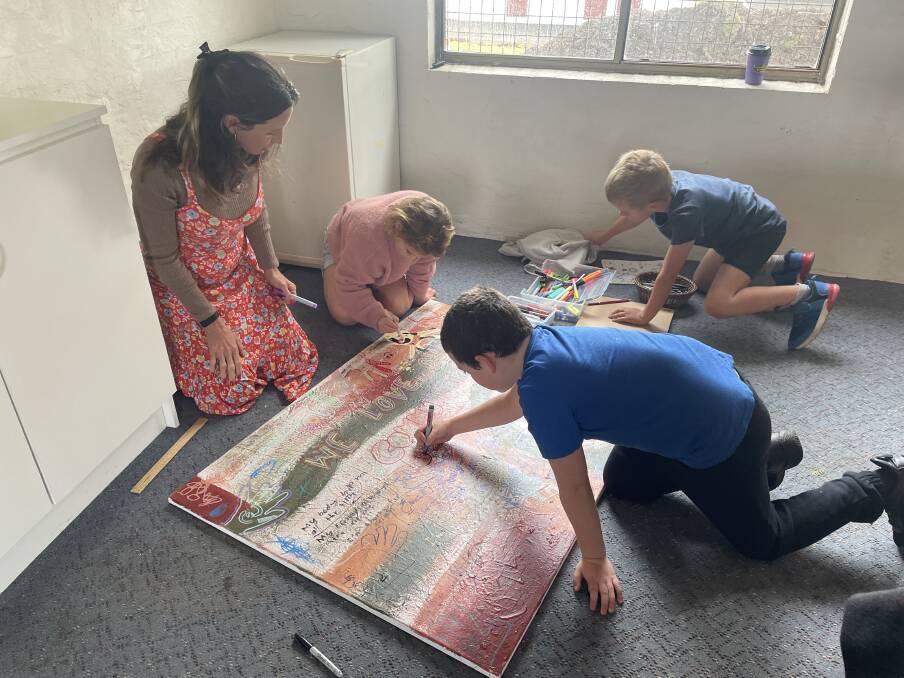Natalie Whitehead encourages home-school kids to add to a collaborative canvas centred around community. Picture by Ellie Chamberlain