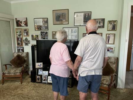 Fay and John admire their wall of family photos in their South Kempsey home in 2023. Picture by Ellie Chamberlain