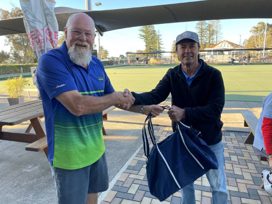 Golf Club President Tim Cross presents Jim Bozinovski with a bag of goodies for his historic hole in one. Picture supplied by Crescent Head Country Club