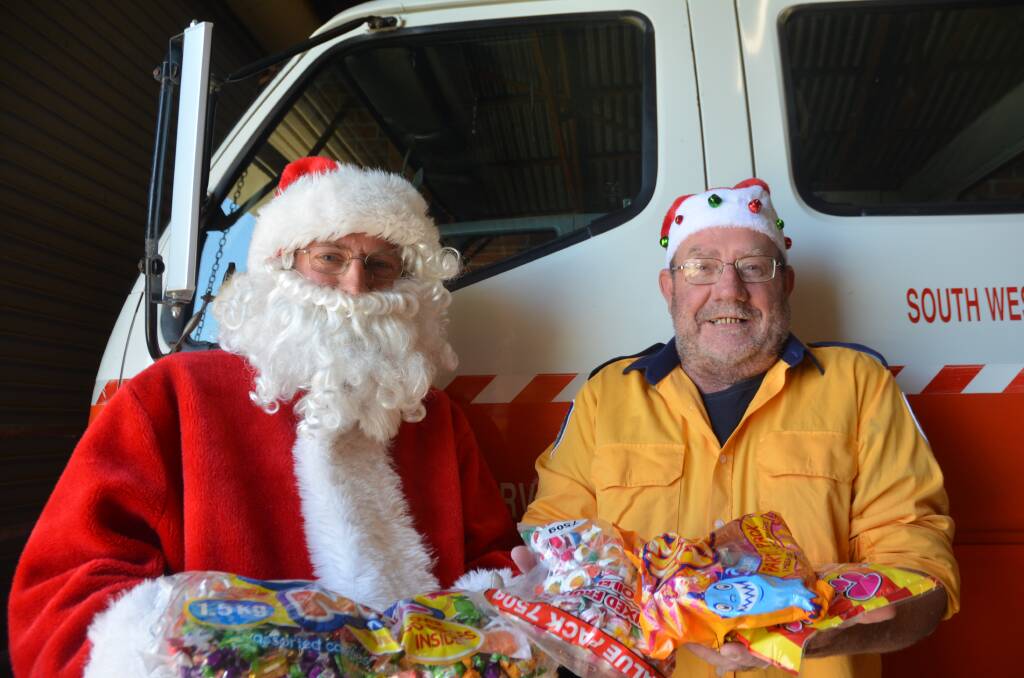 South West Rocks Rural Fire Service volunteer Bryson Hartley and Bernie Connell prepare for this year's Santa run. Picture by Emily Walker