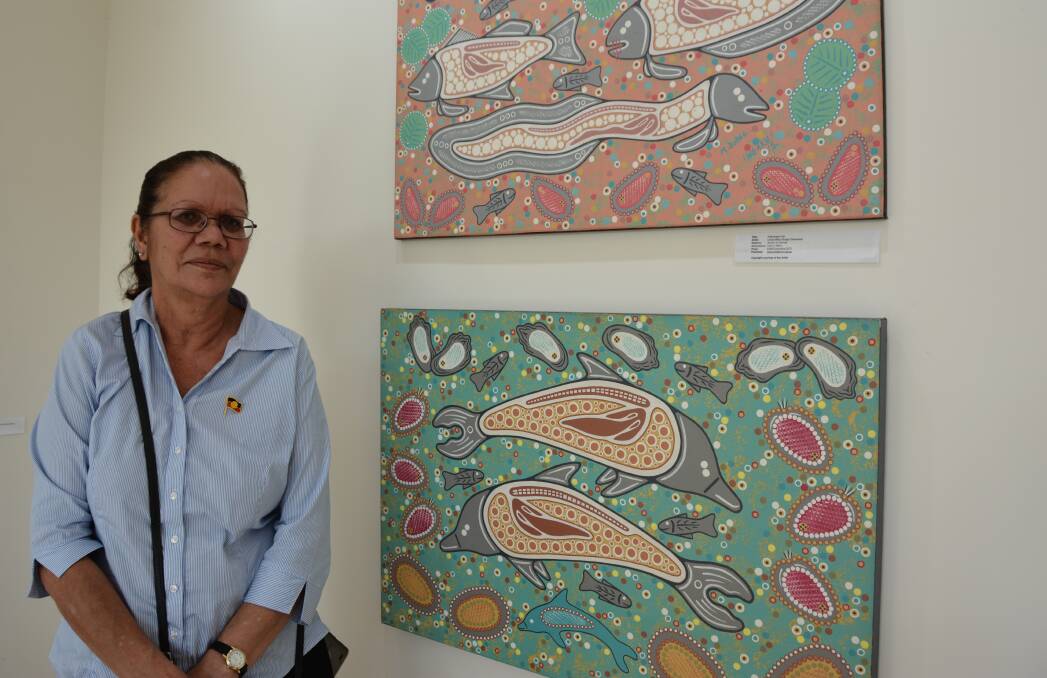 Iris "Dolly" Flanders stands by the artworks created by her late father Uncle Milton Budge (also known as Brian Flanders) in the Coolamon Arts Hub. Picture by Emily Walker