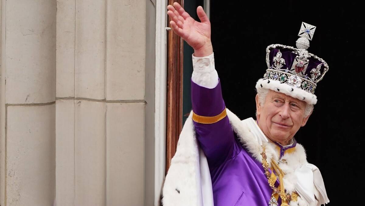 King Charles III steps out, waves from Buckingham Palace after his coronation in May 2023.