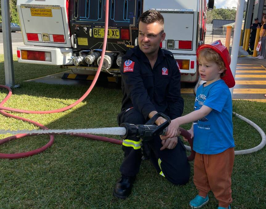 South West Rocks firefighter Trent Evans shows Jack Peake how to operate the hose to put out fires. Picture by Liz Langdale 