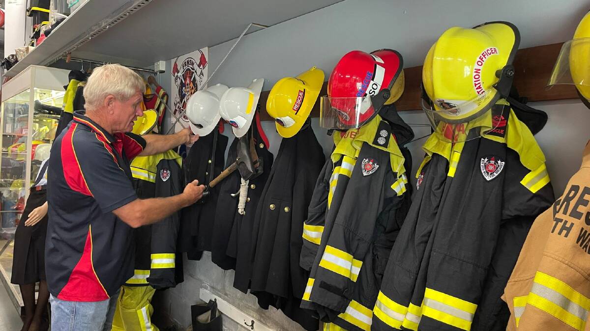 Don Davidson shows how uniforms of firefighters have changed over the years. Picture by Liz Langdale. 