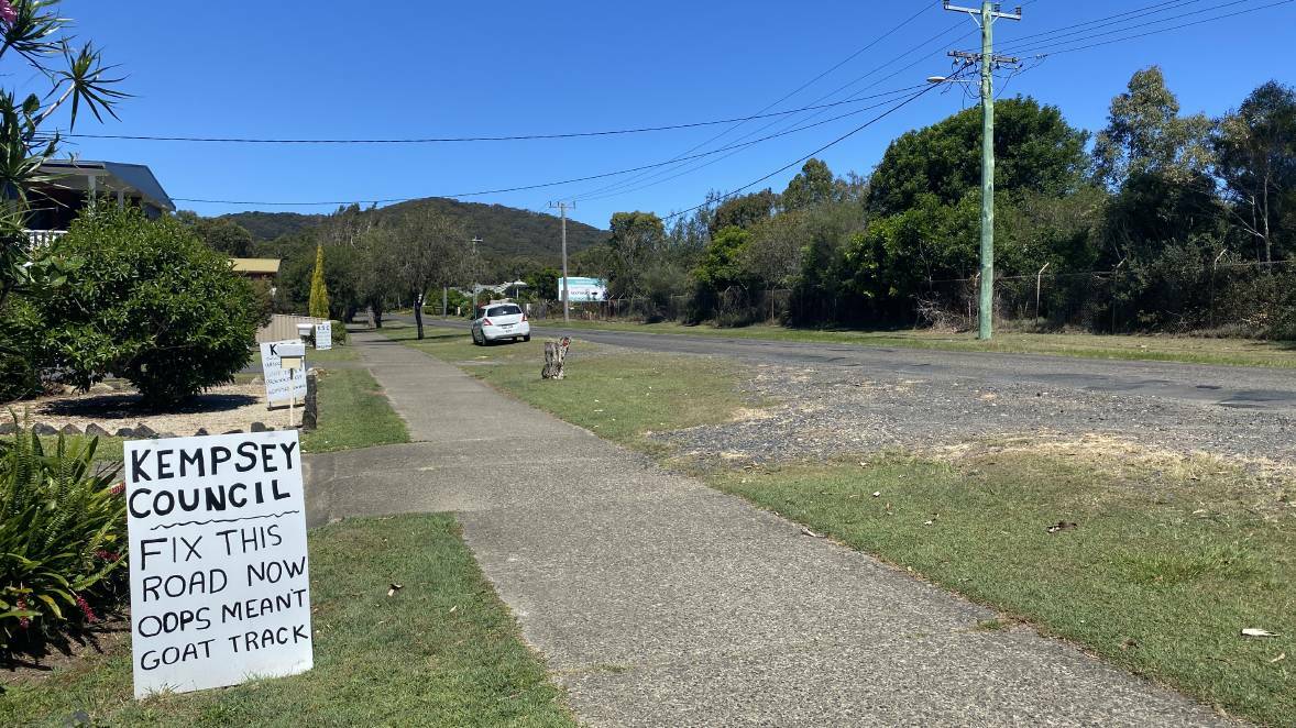 Community erected signs along Phillip Drive at South West Rocks call for Kempsey Shire Council to repair the "goat track" road riddled with potholes. Picture Ellie Chamberlain