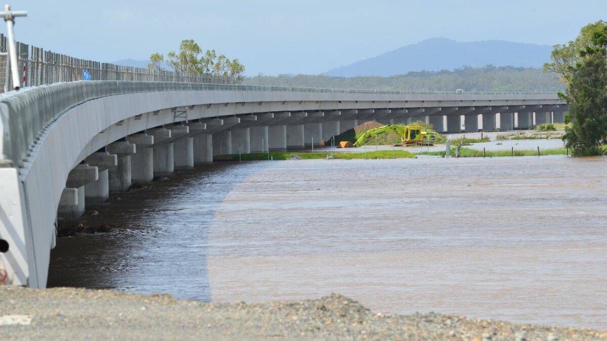 Holding its own: the soon-to-be-opened 3.2km bridge over the Macleay Floodplain has a clearance of 9m above the river at high tide. As Penny Tamblyn’s picture demonstrates, the colossal construction allowed the floodwater to continue its course downriver. The stranded excavator is privately owned.